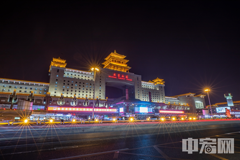 国庆假期期间，北京城内的许多地标建筑都点亮灯光。10月3日，亮灯后的北京西站景色迷人，吸引许多行人和旅客拍照。 中宏网记者 富宇 摄