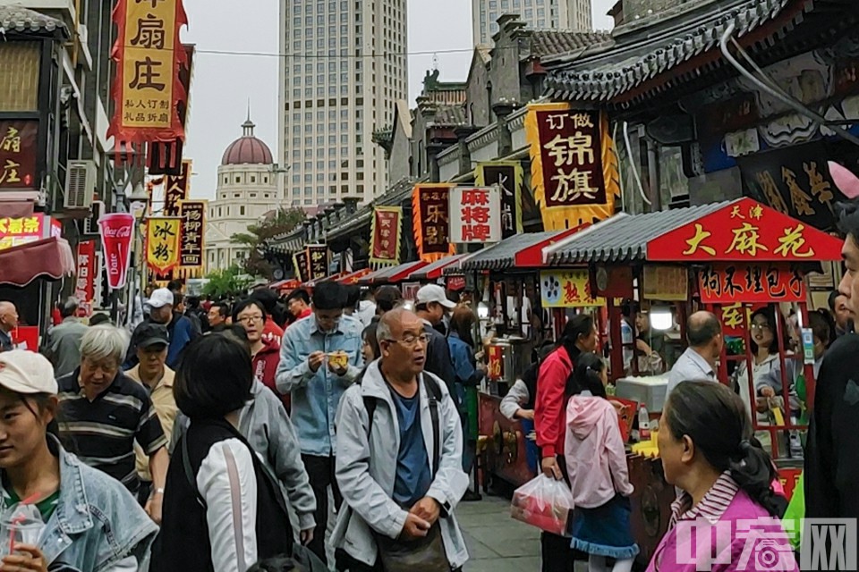10月6日，游客在天津古文化街体验当地特色小吃。中宏网 张肖 摄