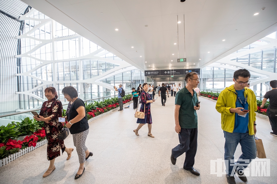 近日，新开放的大兴国际机场成为了不少民众的游览景点。据统计，“高颜值”的大兴国际机场国庆期间共迎来51.84万人次的“打卡游客”。仅10月3日当天，游客数量就达到10.7万人次，是出行旅客的23倍。为服务好参观游客，大兴机场在公共区新开多家餐厅，提供与市区“同质同价”的服务。图为在大兴机场游览的市民和普通旅客。（资料图） 中宏网记者 富宇 摄