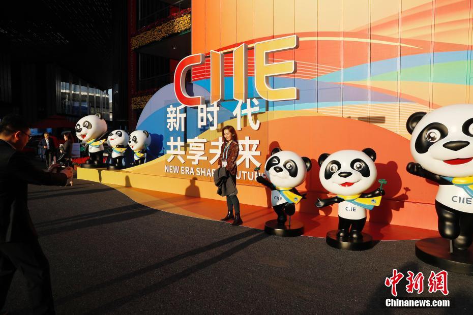 11月5日，参观者与进博会吉祥物熊猫“进宝”合影留念。当日，第二届中国国际进口博览会在上海国家会展中心开幕。中新社记者 殷立勤 摄