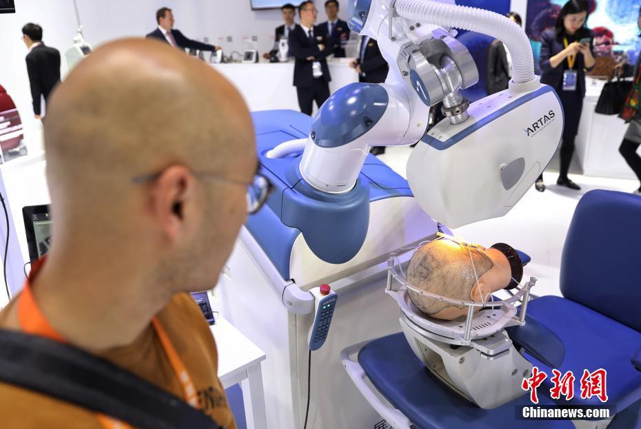 11月6日，第二届进博会正在上海国家会展中心举办。一款植发手术辅助机器人首次亮相展会，该设备在一小时内可以帮助患者植发1500根。中新社记者 张亨伟 摄