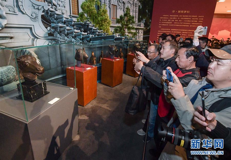 11月13日，观众在“回归之路——新中国成立70周年流失文物回归成果展”上参观圆明园马首铜像（左）。 新华社记者 李贺 摄