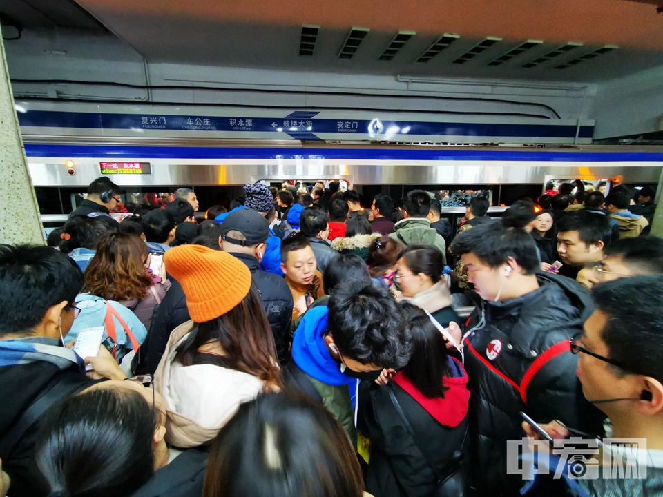 列车停站后，大批等车乘客纷纷涌入车厢。 中宏网记者 富宇 摄