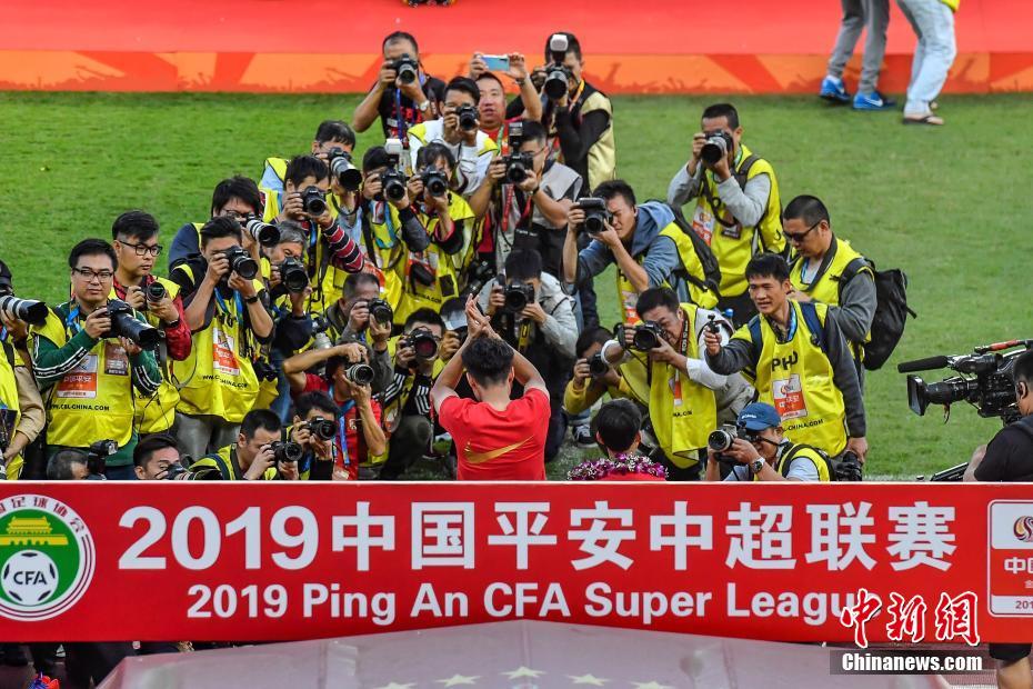 图为广州恒大淘宝队球员郑智（中）在夺冠庆典上受到媒体关注。中新社记者 陈骥旻 摄