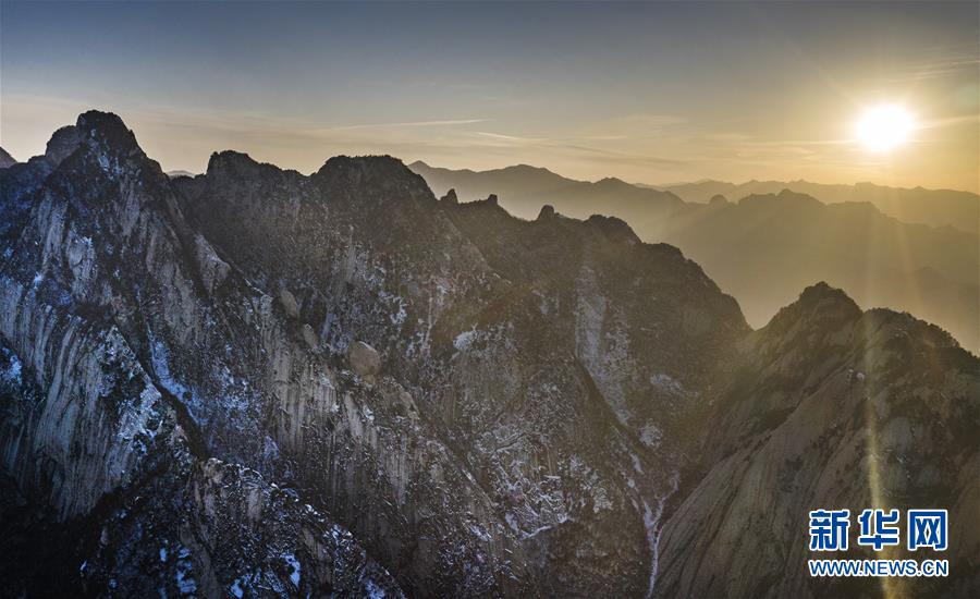 夕阳下的西岳华山（12月4日无人机拍摄）。 冬日的华山，在夕阳的映照下，绽放出炫目的色彩，与蓝色的天空、金色的晚霞构成壮美的画卷。 新华社记者陶明摄