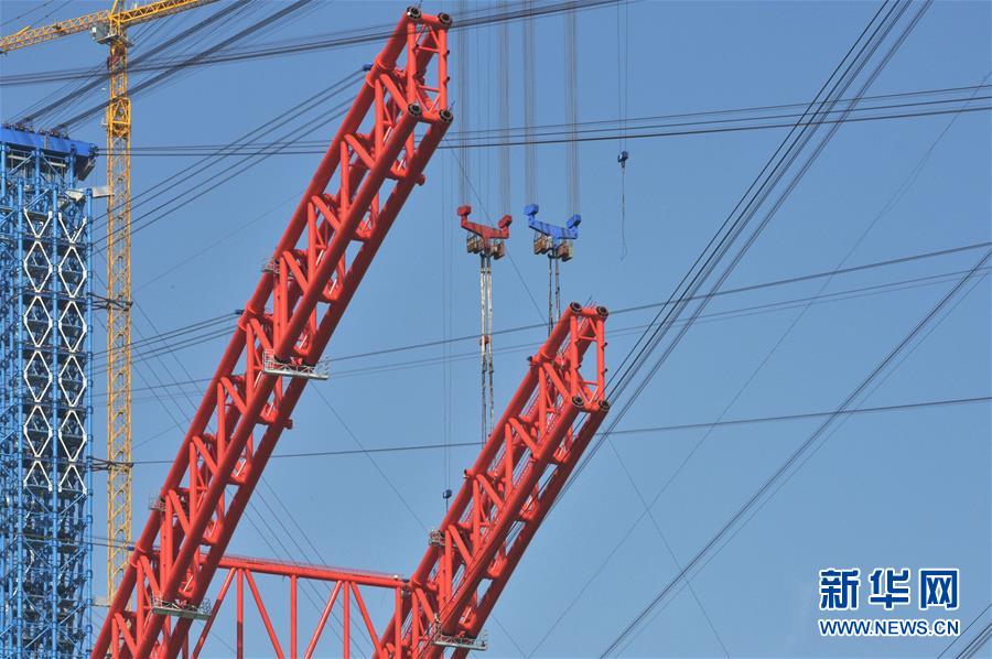 工人在进行大桥主拱拱肋吊装作业（12月8日摄）。 平南三桥位于广西贵港市平南县，是荔玉高速平南北互通连接线上跨越浔江的一座特大桥。大桥于2018年6月开工建设，全长1035米，主桥跨径575米，预计2020年12月底建成通车。 新华社记者 崔博文 摄