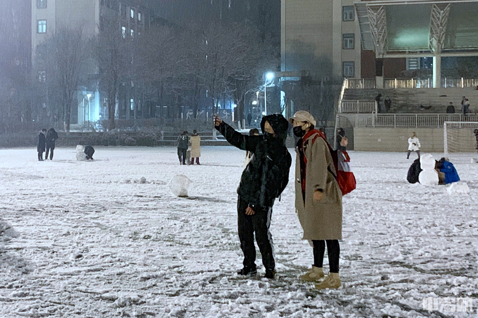 1月5日晚，北京迎来2020年首场降雪。一对情侣在雪中拍照。