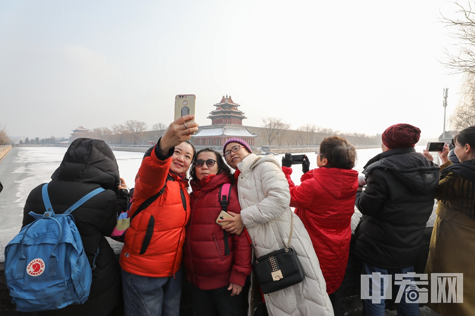 雪景吸引了许多游客到故宫角楼外打卡拍照。 中宏网记者 富宇 摄