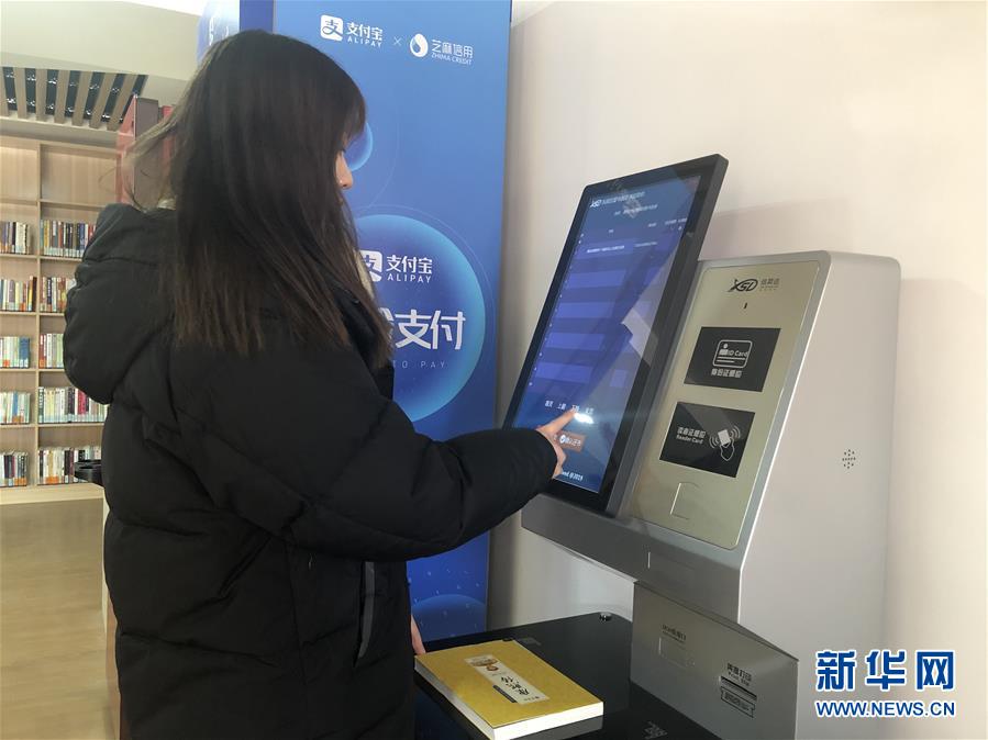 一位读者使用自助借还机办理借还书（2019年12月31日摄）。新华社记者 周润健 摄