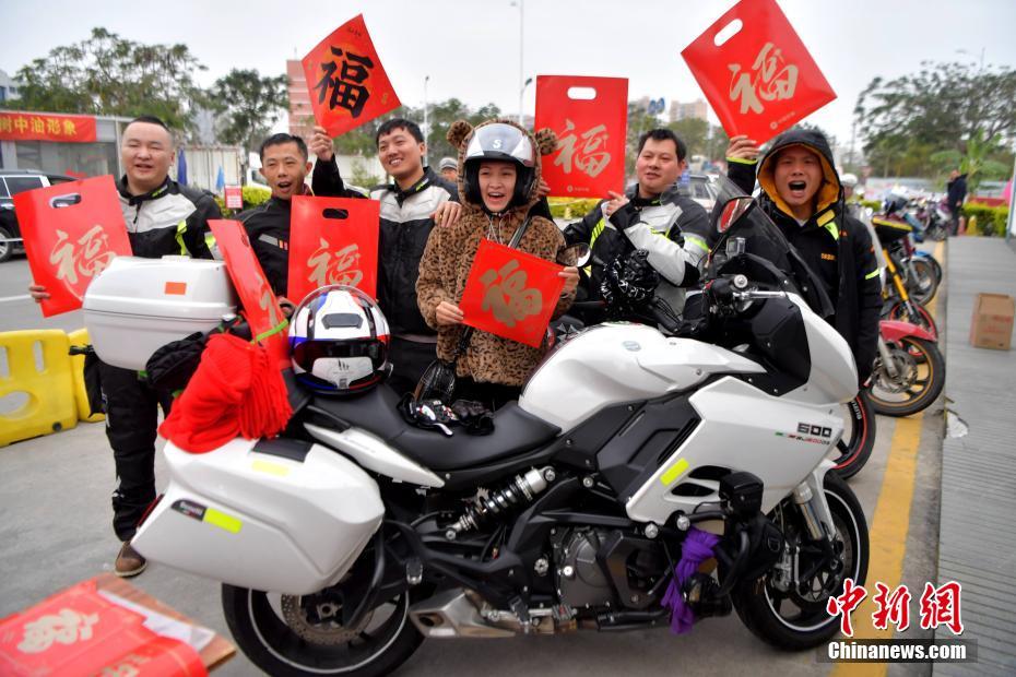 图为在中国石油福建漳州龙江路加油站，骑摩托车返乡的务工人员在一起合影留念。 张斌 摄