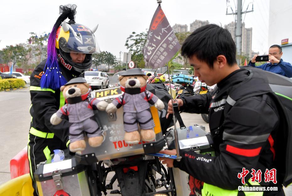 图为在中国石油福建漳州龙江路加油站骑摩托车返乡的务工人员在一起整理行李。张斌 摄
