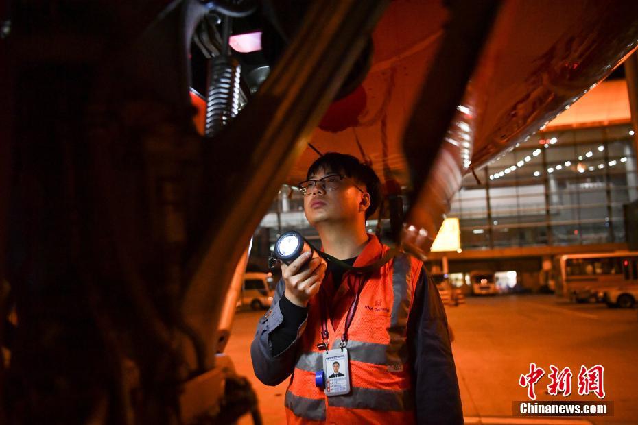 1月14日晚，工程师检查飞机起落架。中新社记者 刘冉阳 摄