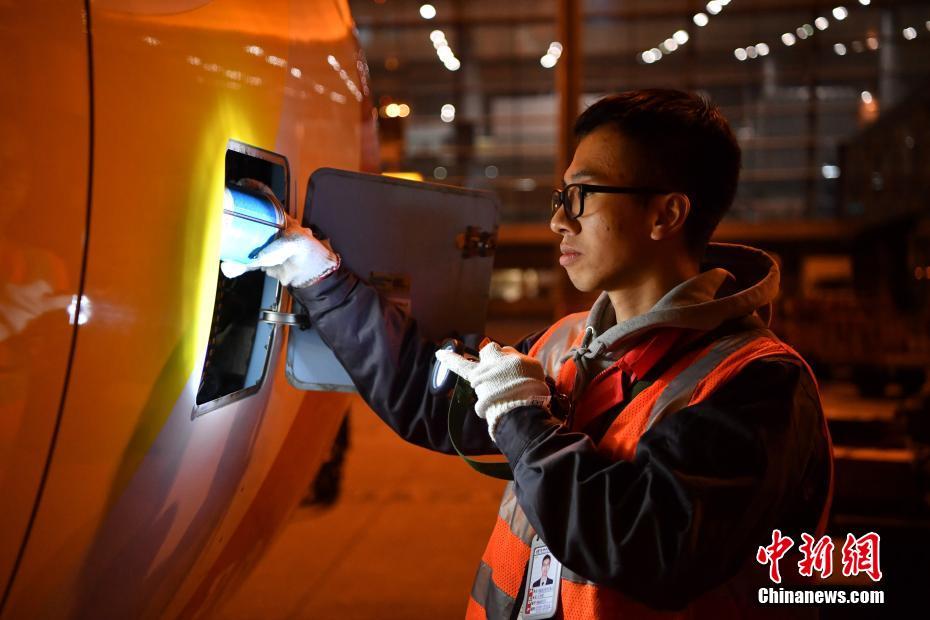 1月15日凌晨，工程师为飞机发动机加入滑油。中新社记者 刘冉阳 摄