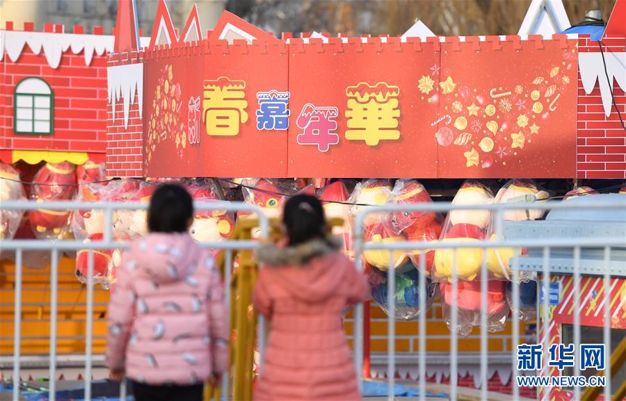 1月19日，两名儿童在北京石景山游乐园眺望装饰一新的游艺区。 春节将至，北京石景山游乐园张灯结彩，装饰一新，并筹备多项主题游园活动喜迎佳节。 新华社记者 李俊东 摄