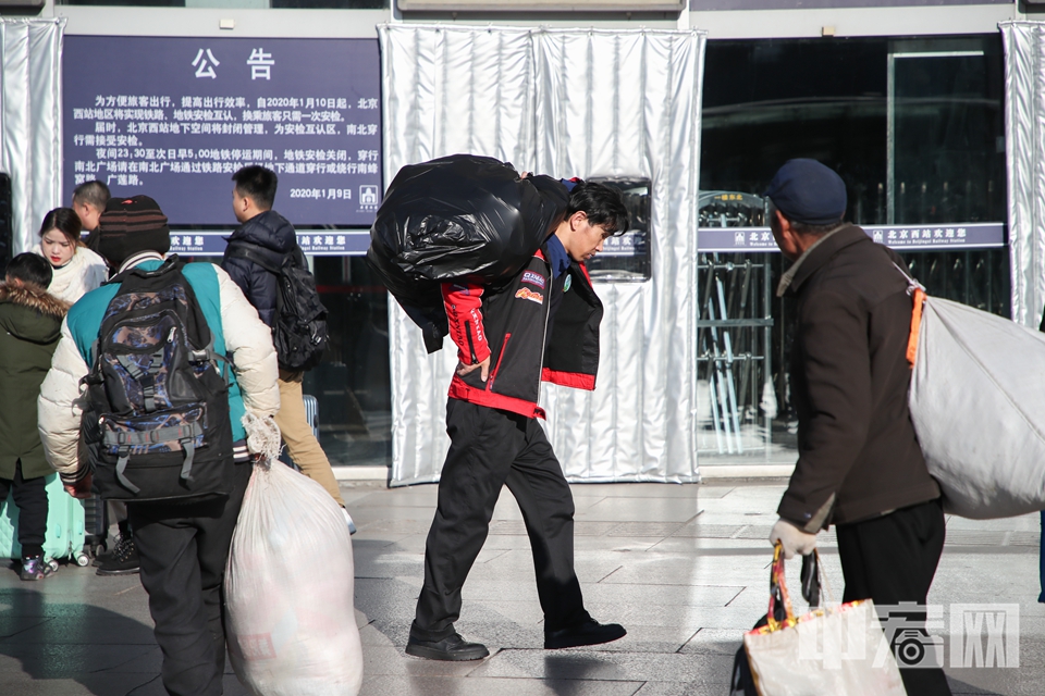 旅客肩扛手提行李准备进站。 中宏网记者 富宇 摄