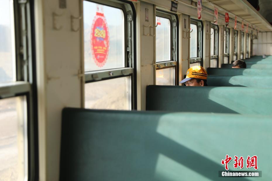 1月20日，在银川开往汝箕沟7524次列车上，乘客向窗外眺望。7524次列车于1972年开始运行，是目前银川客运段“最高龄”的列车之一，列车仅有3节车厢，以不到60公里的时速在贺兰山间行驶。中新社记者 杨迪 摄