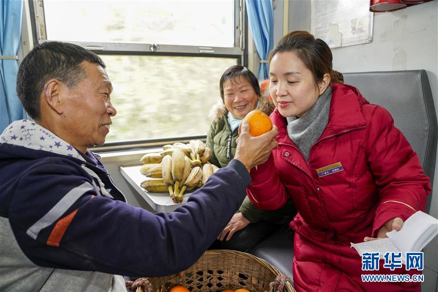 1月20日，在5629次列车上，常年坐这趟车的胡大爷（左一）向列车广播员杜晓霞（右一）介绍自己的优质柑橘。新华社记者 刘潺 摄