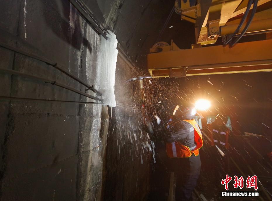 铁路部门有一支特殊的队伍,随着春运渐渐进入高峰,他们也迎来一年中最辛苦最忙碌的时刻。图为1月14日,打冰工人用道镐清除隧道侧壁的结冰。这条线路全程110余公里,一共穿行60个隧道,其中11个隧道结冰现象严重。中新社记者 贾天勇 摄