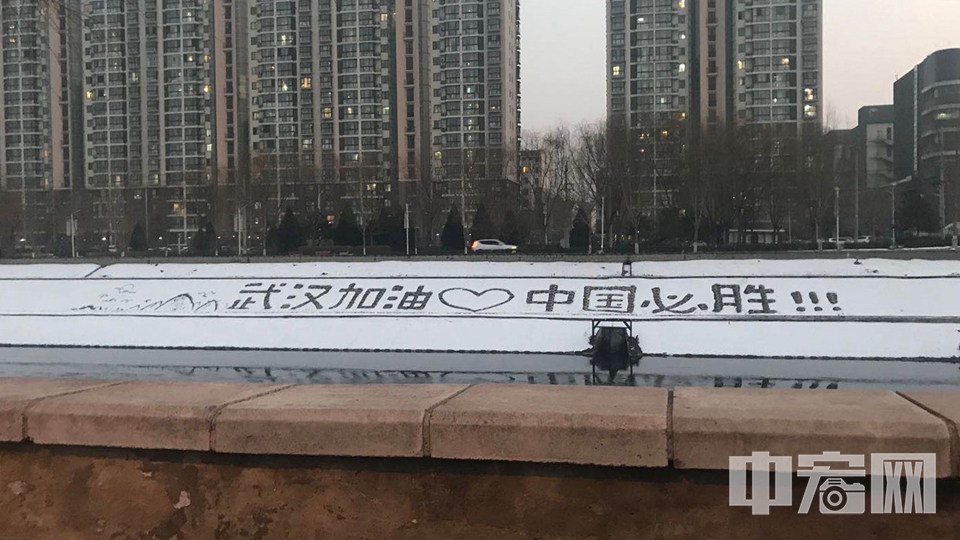 近日，有北京网友在朝阳区通惠河边拍到市民在雪后的岸边写下“武汉加油，中国必胜”，“山川异域，风月同天，劫波渡尽，家国永安”等字样。 胡潇予 摄