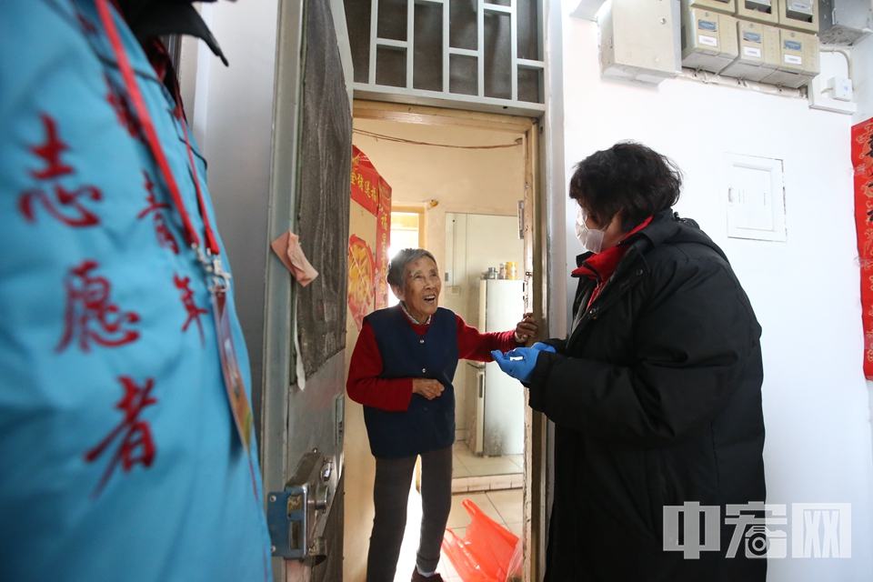 社区工作人员为老年人配送蔬菜。