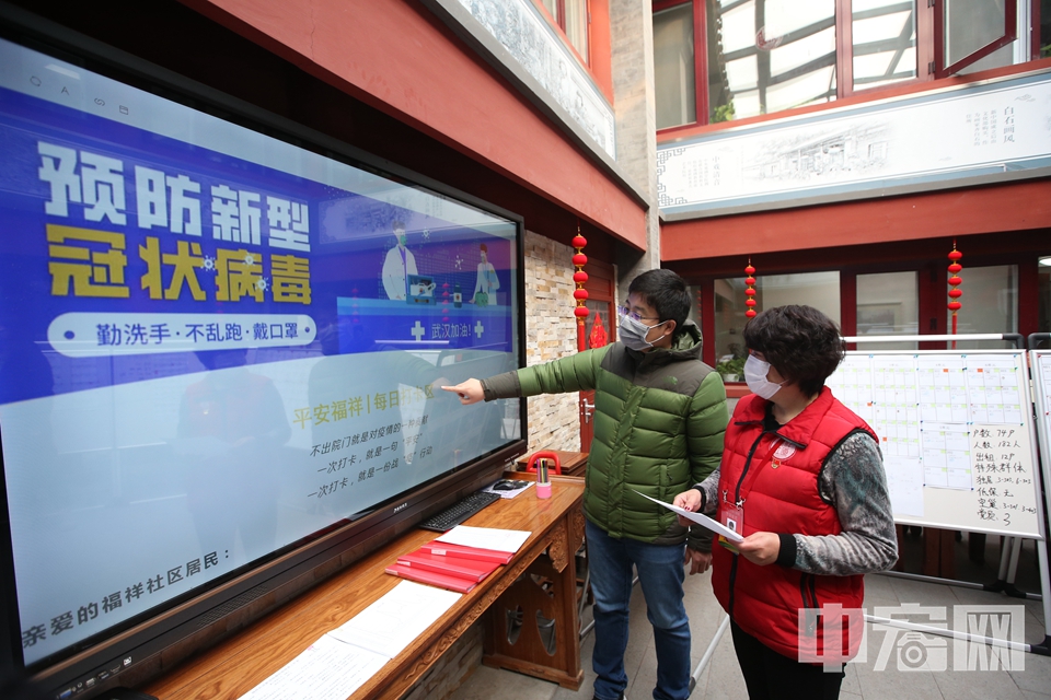社区工作人员用社区网格化防疫工作的辅助工具了解日常情况。