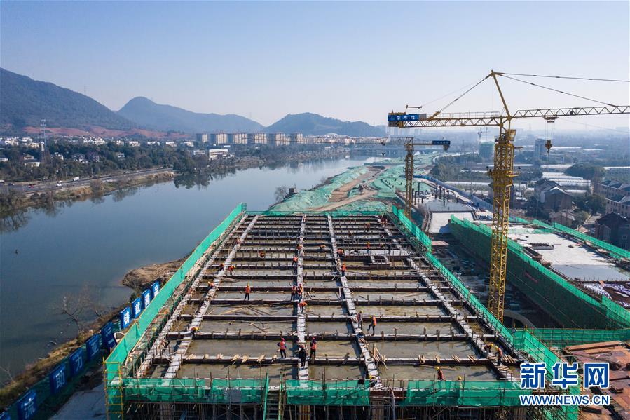 2月20日，在位于杭州市富阳区东洲街道的北支江亚运场馆项目现场，工人在建筑楼顶进行施工（无人机照片）。

　　当日，位于浙江省杭州市富阳区东洲街道的省重点工程——北支江亚运场馆项目全面复工。新冠肺炎疫情发生以来，杭州市富阳区东洲街道党工委成立了重点工程项目复工协调小组，积极协助做好复工准备，包括提供口罩、消毒水、测温仪等物资保障，协调外地员工及时回杭等多方面措施，防疫、复工两手抓，积极推动重点项目复工。北支江亚运场馆项目位于杭州市富阳区北支江南岸，将在2022年亚运会期间承办赛艇、皮划艇等水上项目比赛。

　　新华社记者 徐昱 摄