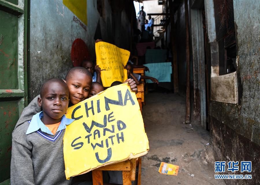 2月19日，在肯尼亚内罗毕，马萨雷贫民窟的小学生展示标语牌，表达对中国的关心和祝福。标语牌上写着：中国，我们和你在一起。 中国和非洲虽然距离遥远，但民心相通，当地民众关注着中国抗击新冠肺炎疫情的消息。在一些国家，孩子们拿起画笔，描绘出他们对中国的支持和鼓励，送上远方的真挚祝福。 新华社记者 李琰 摄