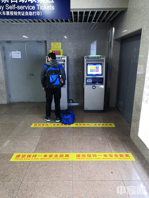 在北京西站的自助取票机前，地上清晰可见一米线。