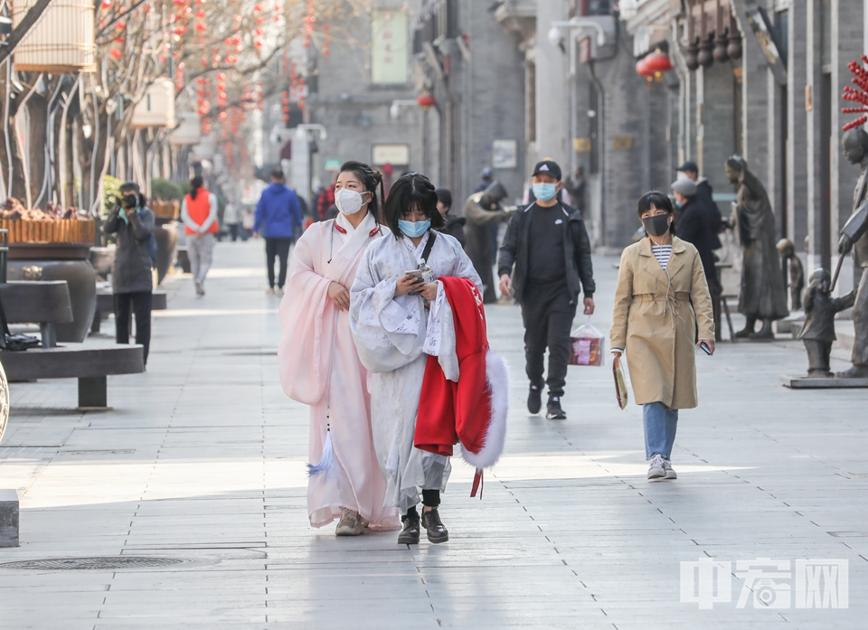进入三月中旬，北京春暖花开，气温不断回升。但受新冠肺炎疫情影响，昔日熙熙攘攘的前门大街上，不少店铺仍旧处于暂时停业的状态。3月17日，北京天气晴好，有部分游客做好防护来到前门大街游览。 中宏网记者 富宇 摄