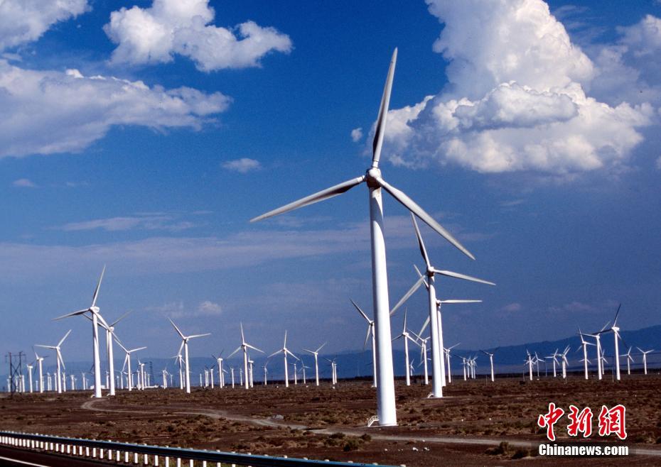 图为中国最大的风力发电场新疆达坂城的风力发电机群在迎风运转