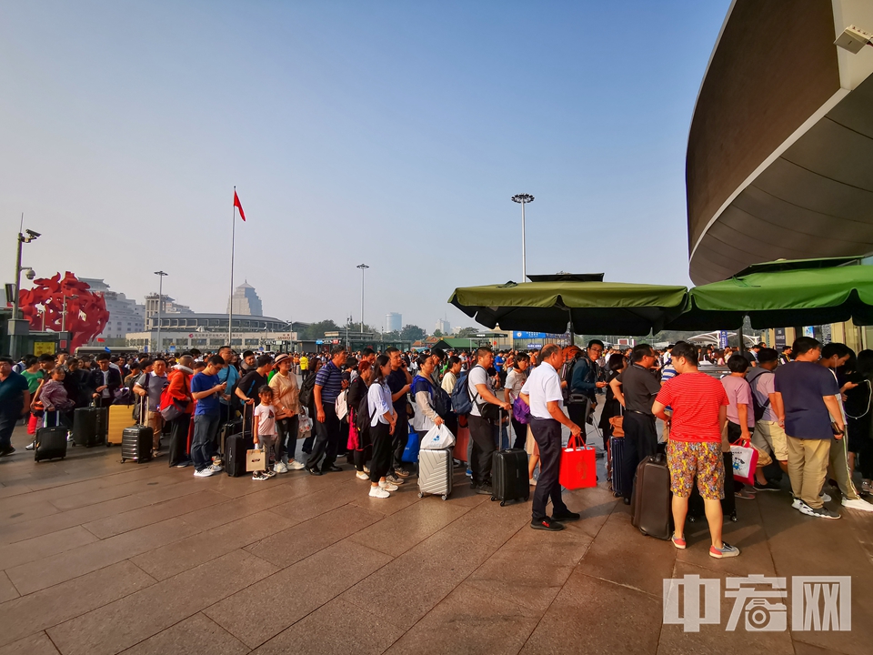 在北京西站南廣場,旅客一大早就在進站口外排起長隊.