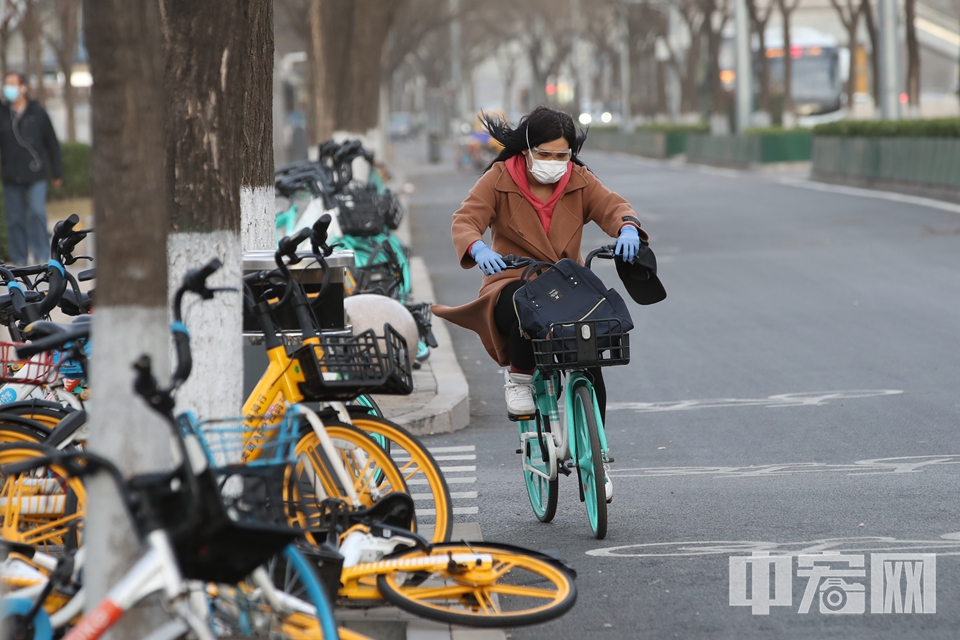 一位市民在大风中奋力骑行。 中宏网记者 富宇 摄