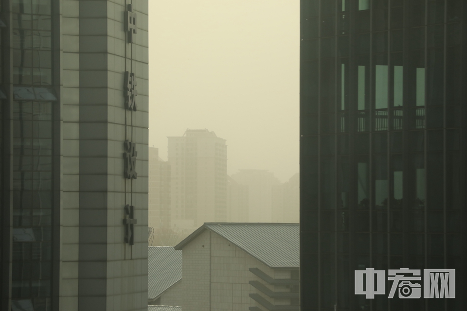 沙尘天气中，远处的建筑变得模糊。 中宏网记者 康书源 摄