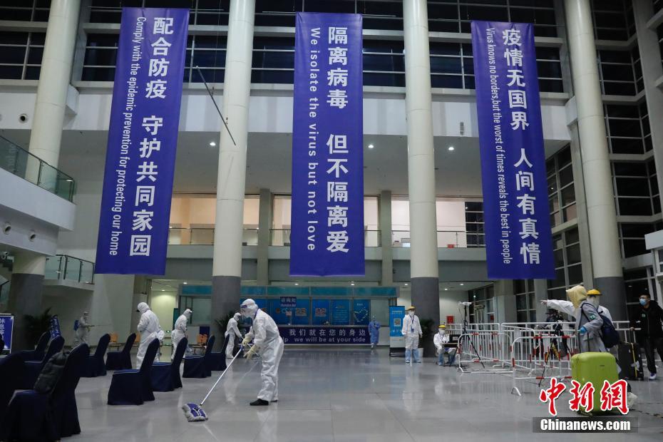 3月23日，位于北京中国国际展览中心新馆的检查入境人员集散点内，旅客拖着行李走进集散点。中新社记者 韩海丹 摄