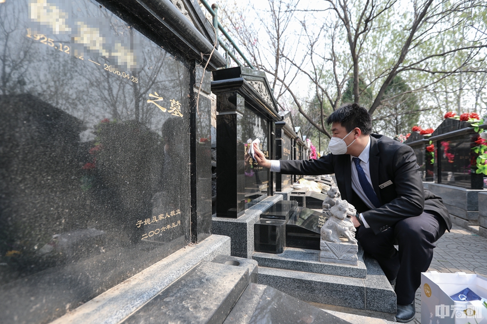 3月30日，北京万佛华侨陵园工作人员正在擦拭墓碑。中宏网记者 康书源 摄