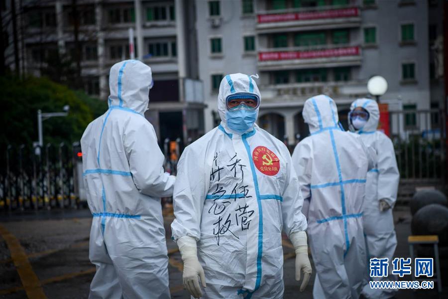 2月28日，在武汉船舶学院，郑州市紧急医疗救援中心主任乔伍营和队员们一起转运新冠肺炎确诊患者。 新华社发