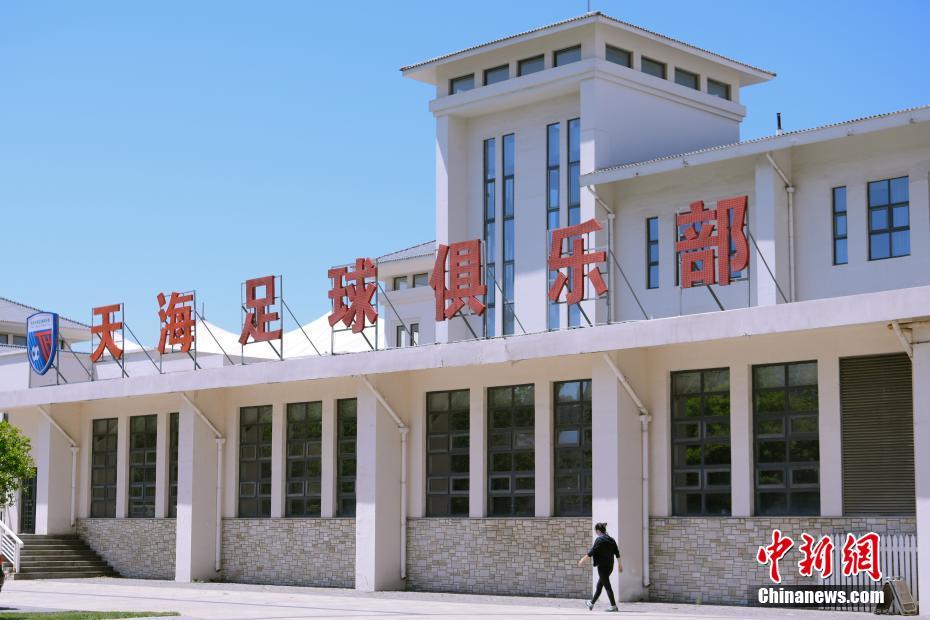 5月12日，一名女子从天津天海足球俱乐部内的建筑物前走过。天津天海足球俱乐部12日发布公告，正式宣告解散。 中新社记者 佟郁 摄
