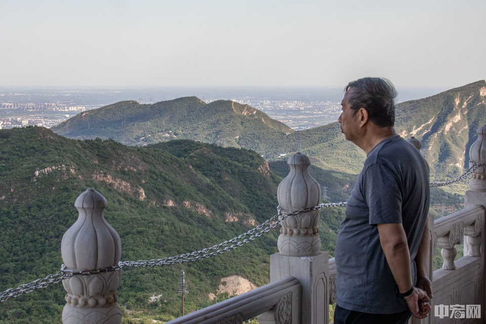 一位市民站在定都阁下俯瞰北京城。