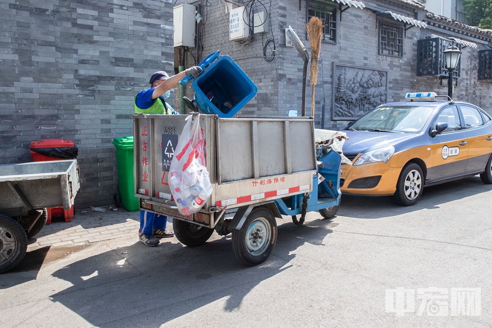 不过，目前北京的垃圾分类工作还任重道远，有不少网友表示自家小区还未开始实行垃圾分类。在西城区二环内的一条胡同内，四色分类垃圾桶数量不足，且环卫人员在清运过程中并未将其他垃圾与可回收物分别堆放，而是一股脑都倒进垃圾车中。（5月19日拍摄） 中宏网记者 富宇 摄