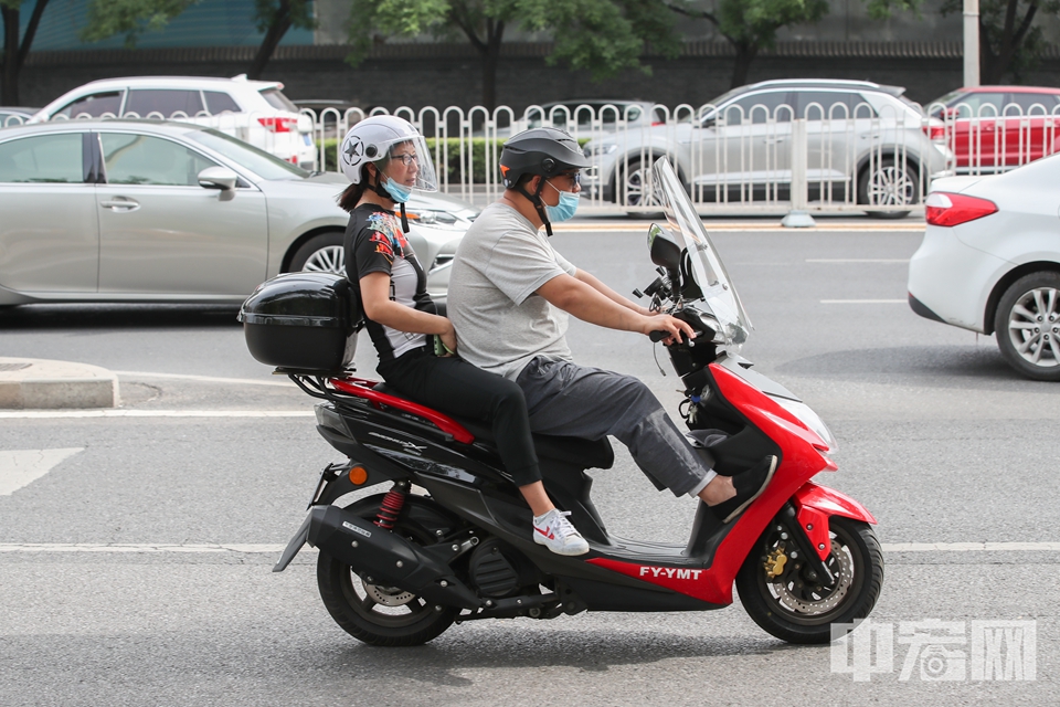 摩托车驾驶员和乘客均佩戴头盔。 中宏网记者 富宇 摄