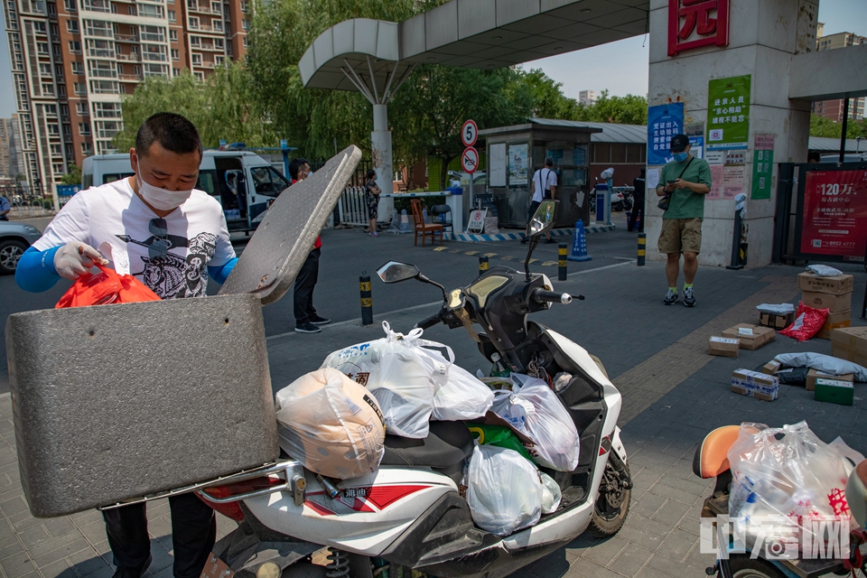 6月18日，北京西城区京铁和园社区，外卖员挑选送往该小区商品。据了解，近日用餐高峰时期的点餐人数较前几日有所下降，但通过外卖平台选购超市果蔬、肉类商品的订单变多了。中宏网记者 康书源 摄