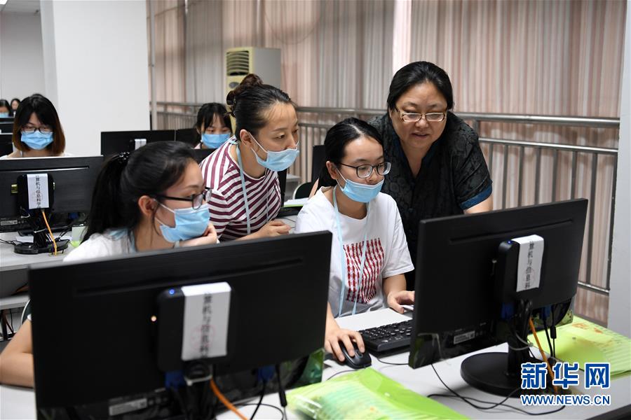 7月12日，在西南大学高考评卷现场，教师们在进行探讨。 新华社记者 唐奕 摄