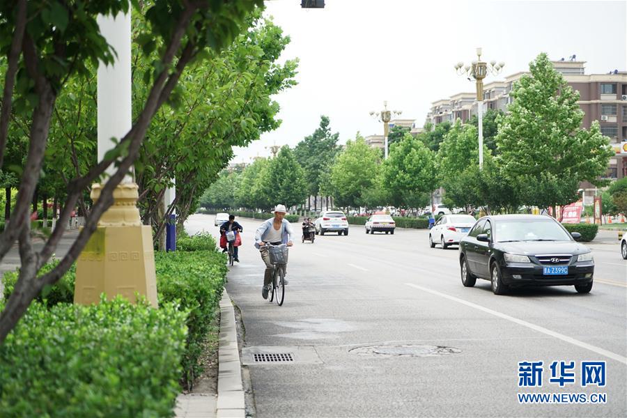 7月12日，市民在河北省唐山市古冶区城区街道上骑行。 新华社记者 牟宇 摄