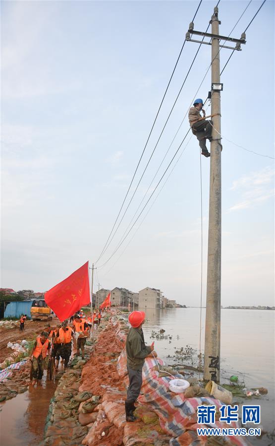 在江西鄱阳县昌江圩，工作人员在修理电缆（7月12日摄）。新华社记者 胡晨欢 摄