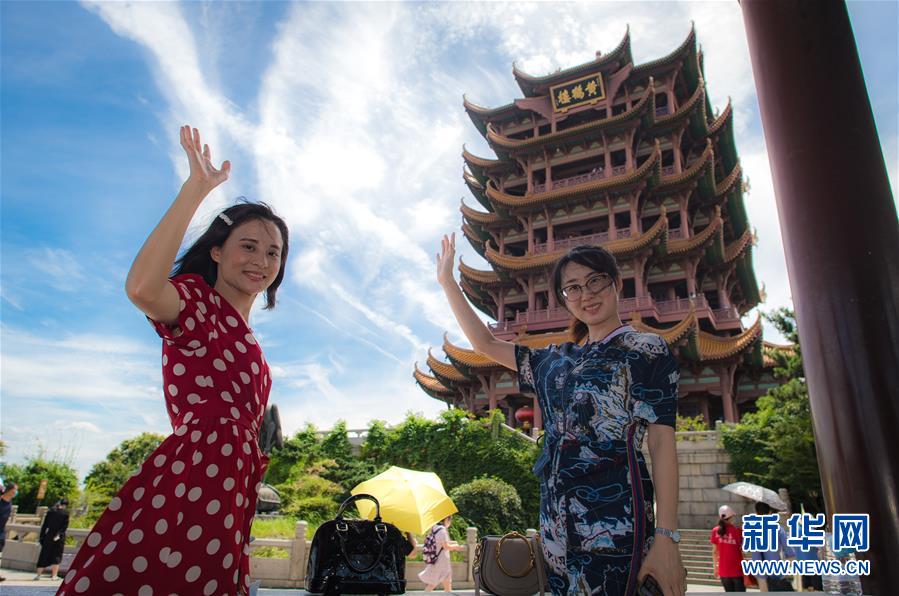 8月7日，受邀来湖北旅游的海南援鄂医疗队员陈小妹（左）与同事计超在黄鹤楼景区观光。新华社记者 肖艺九 摄