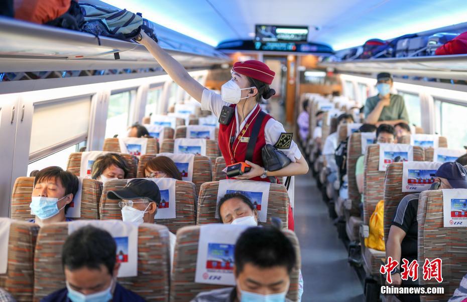 8月10日，北京北站开往太子城站的G8811次高铁列车上，列车长吕盼在整理行李架。随着北京新冠肺炎疫情形势好转，乘坐京张高铁出行的乘客逐渐增多。 中新社记者 贾天勇 摄