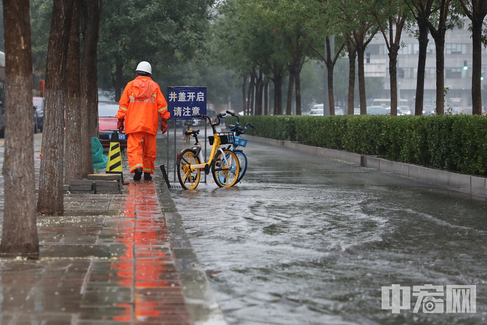8月12日，北京出现入汛以来最强降雨。在大雨中，一群特殊的身影坚守在工作岗位上，保障着城市的运行和安全。图为一位北京排水工作人员在大雨中打开雨篦，缓解道路积水情况。 中宏网记者 富宇 摄