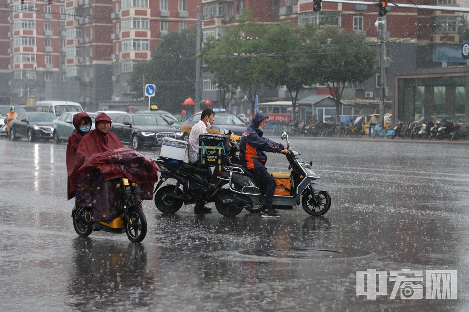 民众冒雨骑行。 中宏网记者 富宇 摄