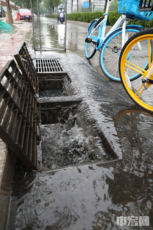 路旁的雨篦被打开以缓解积水。 中宏网记者 富宇 摄