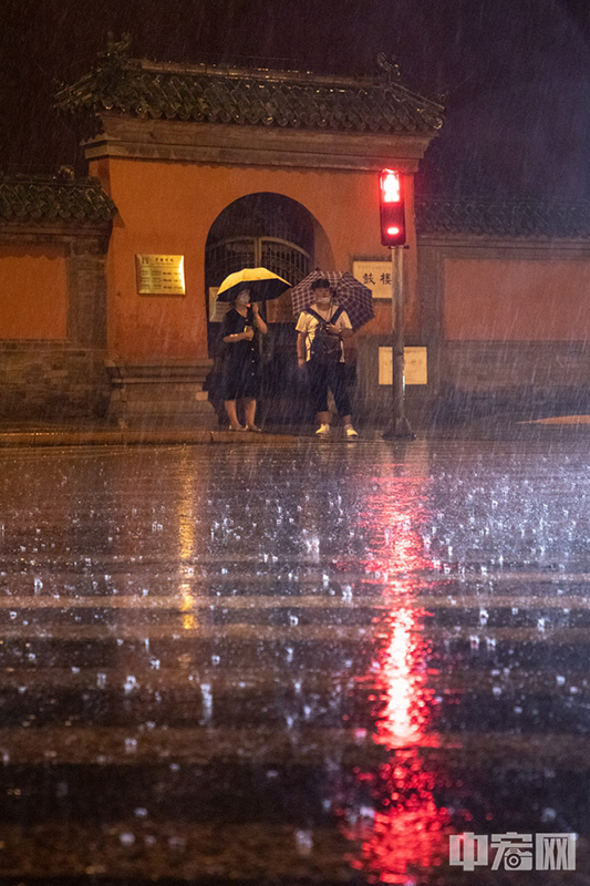 雨中出行的民众。 中宏网记者 富宇 摄
